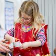 Teacher helping during a DT session for primary pupils cutting an egg box